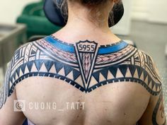 the back of a woman's upper body with tattoos on her shoulder and chest