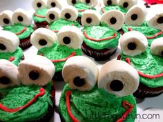 cupcakes with green frosting and white icing decorated to look like monsters