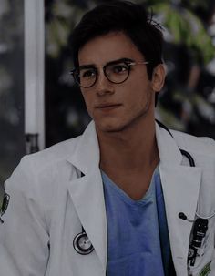 a man with glasses and a white coat is looking at the camera while wearing a stethoscope