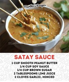 the recipe for satay sauce in a bowl with chopsticks and cilantro