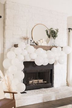 a white balloon arch in front of a fireplace