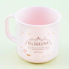 a pink coffee cup with the words rilakkuma printed on it's side