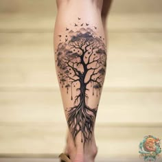 a woman's leg with a tree tattoo on it