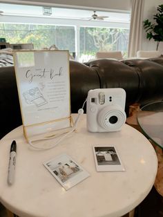 a white table topped with a camera and pictures