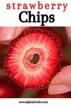 a person holding up a piece of fruit with the words strawberry chips on it