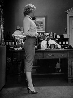 a woman is standing in front of a desk