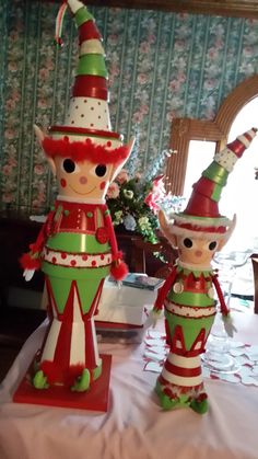 two christmas decorations sitting on top of a table