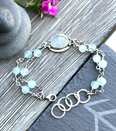 "light blue aquamarine encased in sterling silver bracelet. Dimensions: length 19cm/7,5\", best fits a 6,5\" - 7,5\" wrist;   The bracelet is slightly adjustable with hammered circles, oxidized and polished to enhance the detail of the metalwork. The bracelet is handcrafted with care in my studio. Purchases are nicely packaged, ready for gift giving or a special treat for yourself.  Matching ring is available in my shop: https://www.etsy.com/listing/1519668690/sterling-silver-ring-with-faceted?c Adjustable Silver Aquamarine Bracelets, Silver Double Strand Bracelet With Natural Stones, Silver Double Strand Bracelets With Gemstone Beads, Adjustable Silver Aquamarine Bracelet, Adjustable Aquamarine Bracelets With Natural Stones, Handmade Adjustable Aquamarine Bracelet, Adjustable Aquamarine Silver Bracelet, Silver Bracelets With Amazonite And Natural Stones, Silver Amazonite Jewelry With Natural Stones