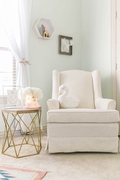 a white chair sitting next to a table in a living room