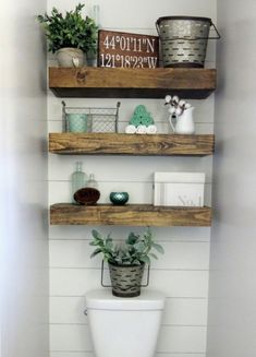 the bathroom is decorated in white and has wooden shelves with plants on top of it