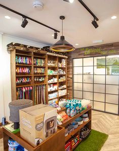 the inside of a store with lots of items on shelves and green carpeted flooring