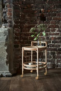 a table with two plates and a vase on it in front of a brick wall