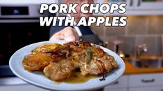 a man holding a plate with some food on it and the words pork chops with apples