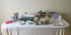 the table is covered with dishes, utensils and other kitchen items that are on it