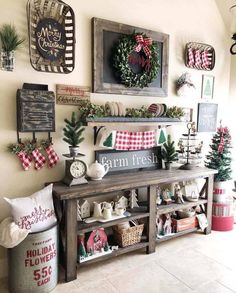 a christmas display with wreaths and other holiday decorations on the wall behind a wooden table