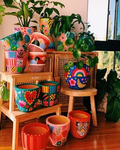 colorful pots and planters on display in front of a window