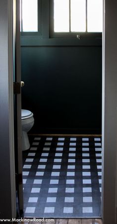 an open door leading to a bathroom with black and white tile