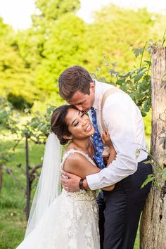 a bride and groom standing next to each other in front of a tree at their wedding