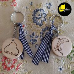 two wooden key chains with different designs on them