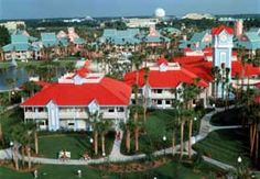 the resort is surrounded by palm trees and other tropical buildings, including two towers with red roofs