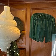 two lamps hanging from the ceiling next to a christmas tree with lights on it and other decorations