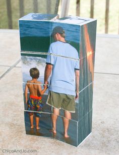 a man standing next to a little boy in front of a box with pictures on it