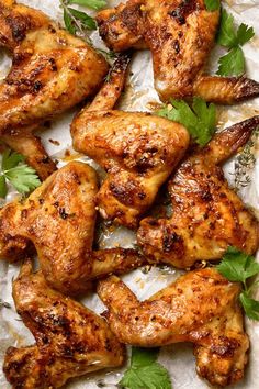 grilled chicken wings with herbs and parsley on parchment paper, ready to be served