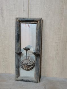 an old mirror is sitting on a shelf