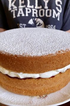 a person holding a cake on a white plate