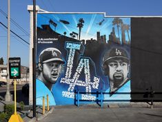 a large mural on the side of a building depicting two baseball players in blue uniforms