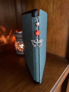 an open book on a wooden shelf next to a candle