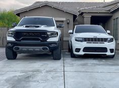 two white trucks parked in front of a house