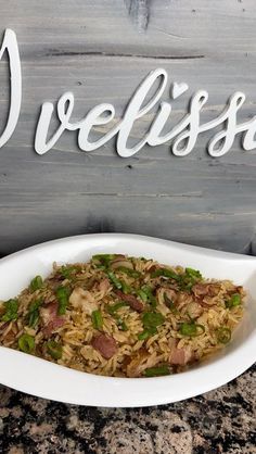 a bowl filled with rice and vegetables on top of a counter next to a sign