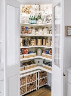 an open pantry filled with lots of food and storage items in baskets on the shelves