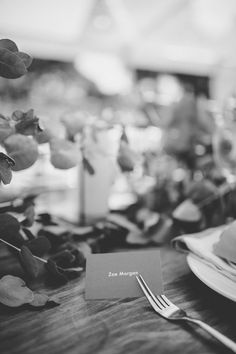 black and white photo of table setting with place settings, flowers and napkins on plate