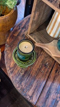 a wooden table topped with a green cup and saucer