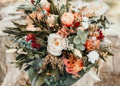 a bouquet of flowers sitting on top of a rock