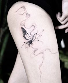 a woman's thigh with a butterfly tattoo on her left leg and the word love written in black ink