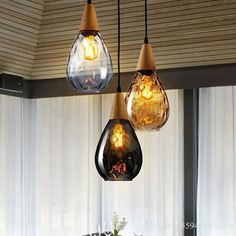 three lights hanging from a ceiling with curtains in the background