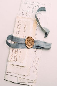 an old envelope with a wax seal on it and blue ribbon tied around the clasp