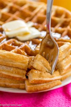 the waffles are stacked on top of each other and being drizzled with syrup