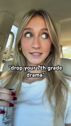 a woman with long blonde hair sitting in the back seat of a car and looking up at the camera