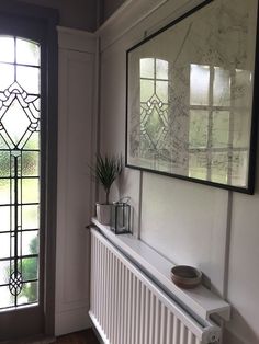 a white radiator in front of a large window