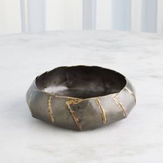 a metal bowl sitting on top of a white table