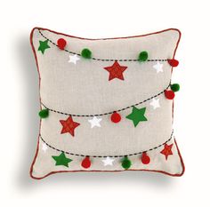 a white pillow with red, green and white stars hanging from it's sides