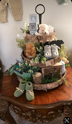 a wooden table topped with a tiered cake covered in stuffed animals