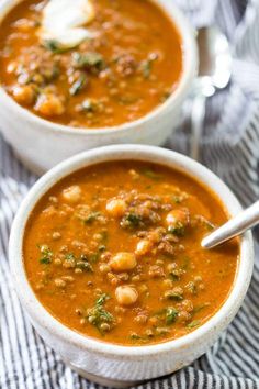 two white bowls filled with soup on top of a table