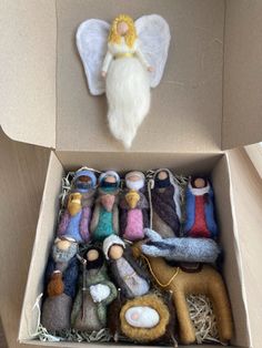 a cardboard box filled with lots of different types of needled dolls in it's packaging