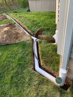 a drain in the ground next to a house