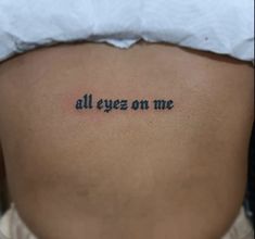 a woman's back with the words all eyes on me written in cursive font